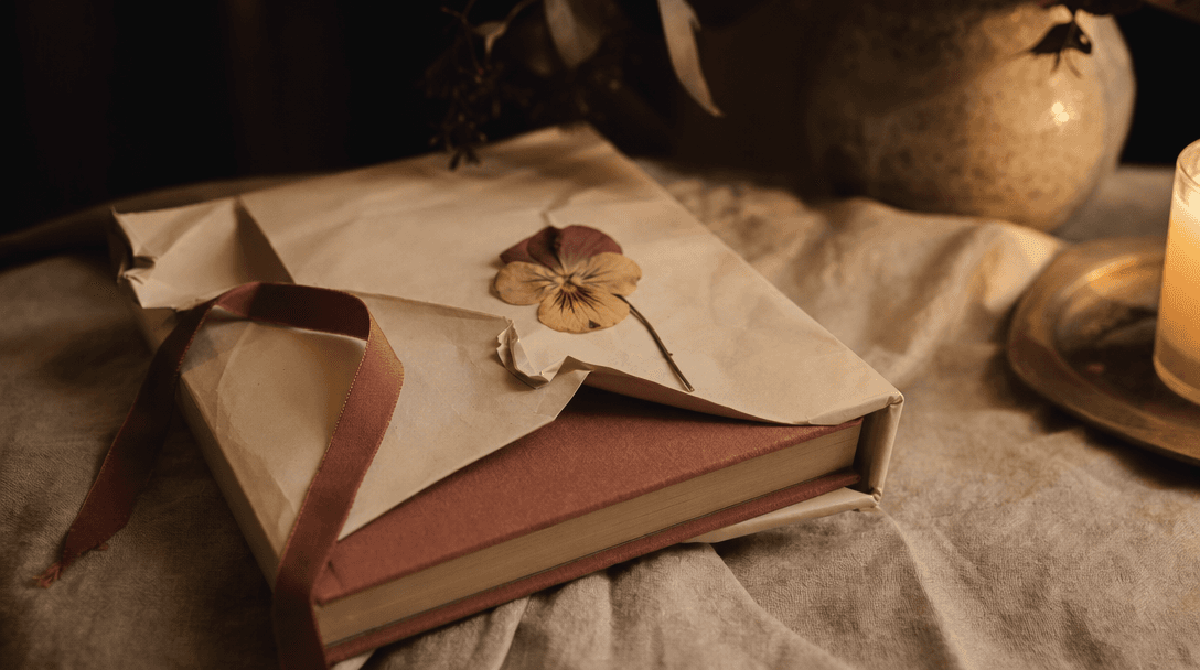 Cahier ouvert sur une table en bois clair, papier crème, ambiance feutrée