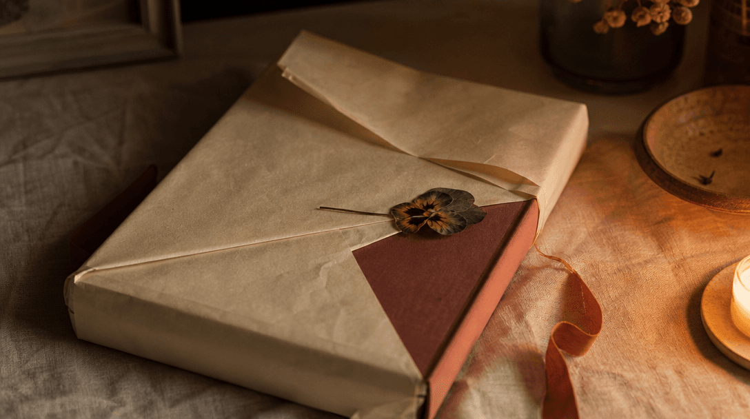 Bouquet de roses pâles posé sur une table en bois aux côtés d'une lettre manuscrite