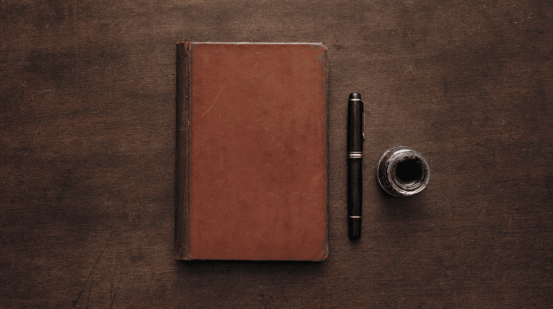Cahier ouvert sur une table en bois clair, papier crème, ambiance feutrée