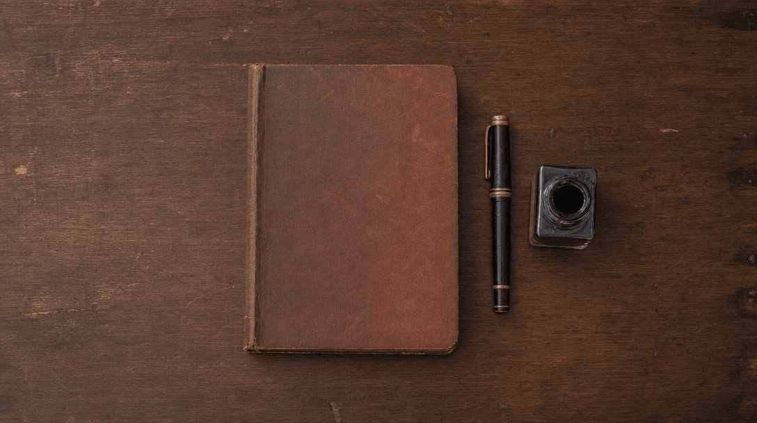 Cahier ouvert sur une table en bois clair, papier crème, ambiance feutrée